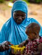 A 10-month-old girl puts her hand in the plate containing the fortified porridge to drink it by hand.  ? WFP/Cheick Omar Bandaogo